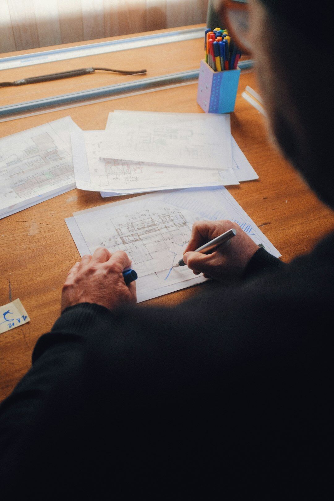 Person writing notes at a desk surrounded by books on communication