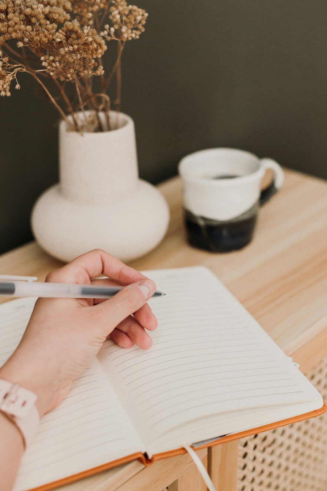 Hands writing personal development notes in a notebook