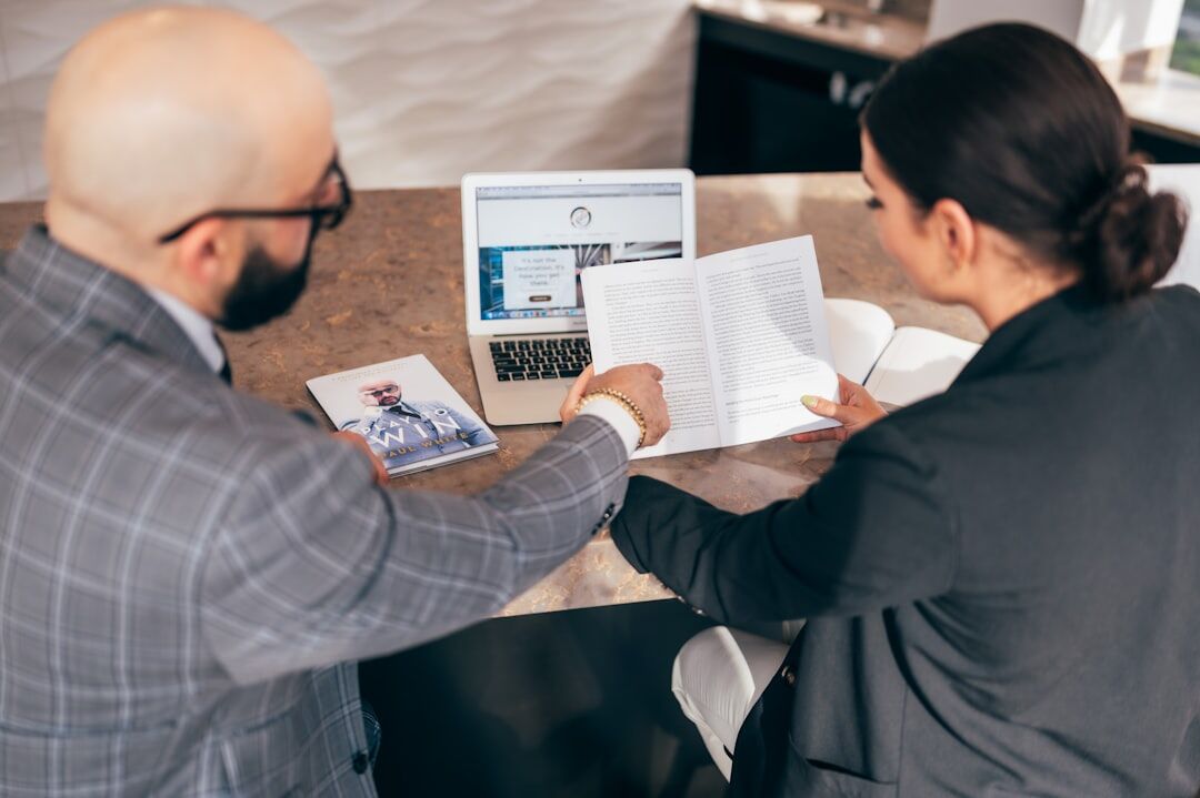 Close-up of two people exchanging feedback notes at a desk