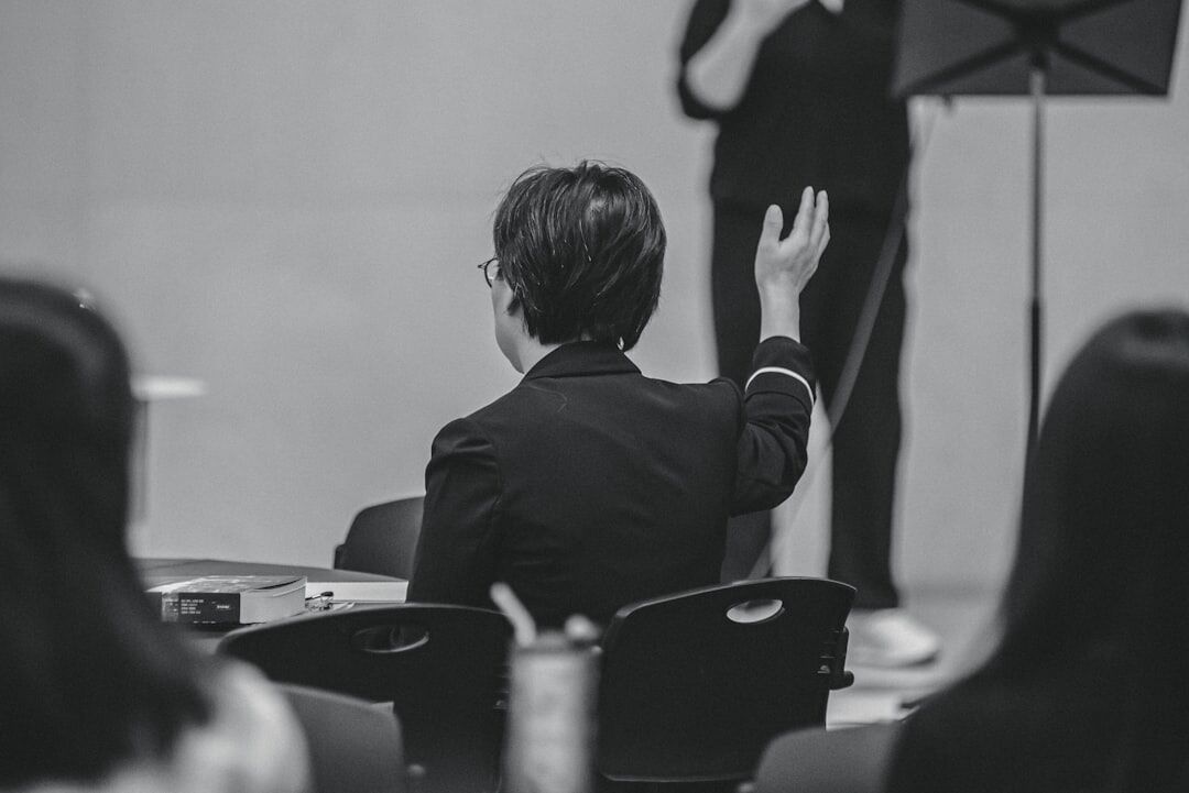Person speaking confidently in front of a small seated audience
